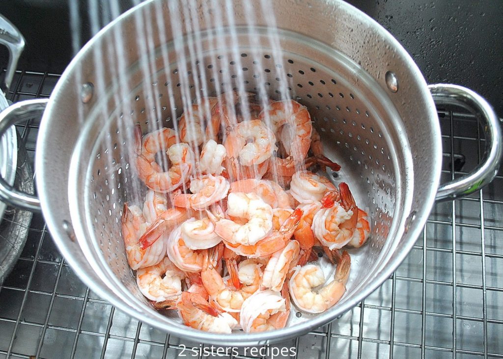 Cooked shrimp under running water. by 2sistersrecipes.com 