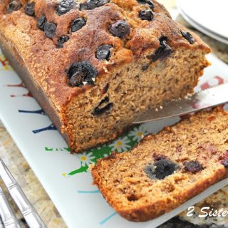 A slice of blueberry banana bread on a platter. by 2sistersrecipes.com
