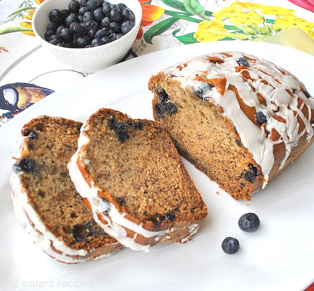A breakfast bread loaded with fresh blueberries inside and glazed drizzled on top.