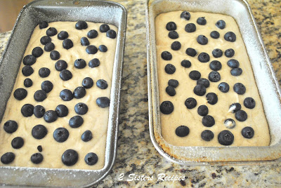  Two 9-inch baking bread pans filled with the banana batter with fresh blueberries scattered on top. by 2sistersrecipes.com 