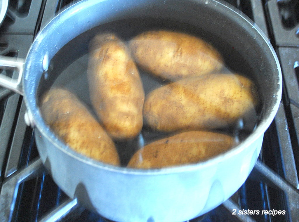 5 potatoes in a pot filled with water. by 2sistersrecipes.com