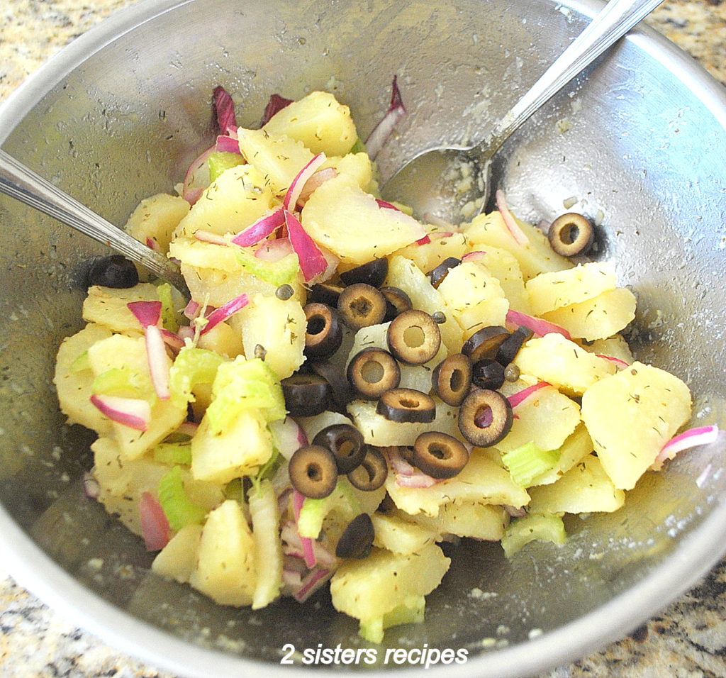 Potato salad in a mixing bowl. by 2sistersrecipes.com 