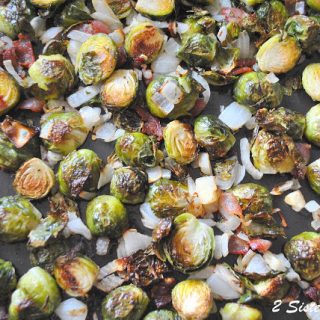 A large sheet pan with roasted Brussels sprouts, chopped onions and bacon.