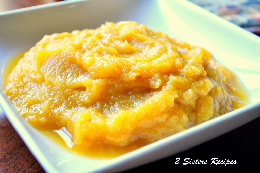 A square-shaped white bowl filled with fresh pumpkin puree.