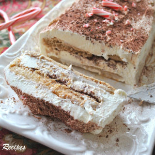 A slice of peppermint tiramisu on a white long cake platter.
