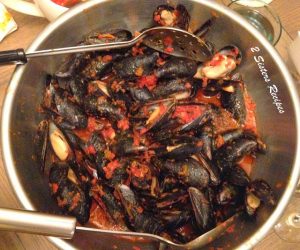 Mussels steamed with tomatoes in a silver bowl.