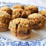A blue and white plate filled with stuffed mushrooms caps.