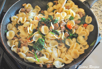 A large skillet with little ears pasta, spinach and crumbled sausages. by 2sistersrecipes.com