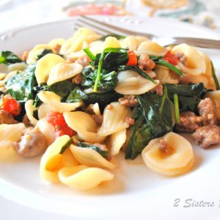 Orecchiette with Sausages and Spinach served on a white dinner plate with a fork.