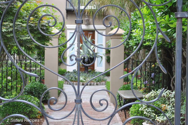Viewing a garden thru a decorative wrought iron gates of Charleston, SC