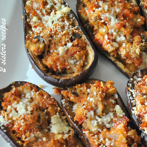 A white platter filled with stuffed eggplants baked until softened.