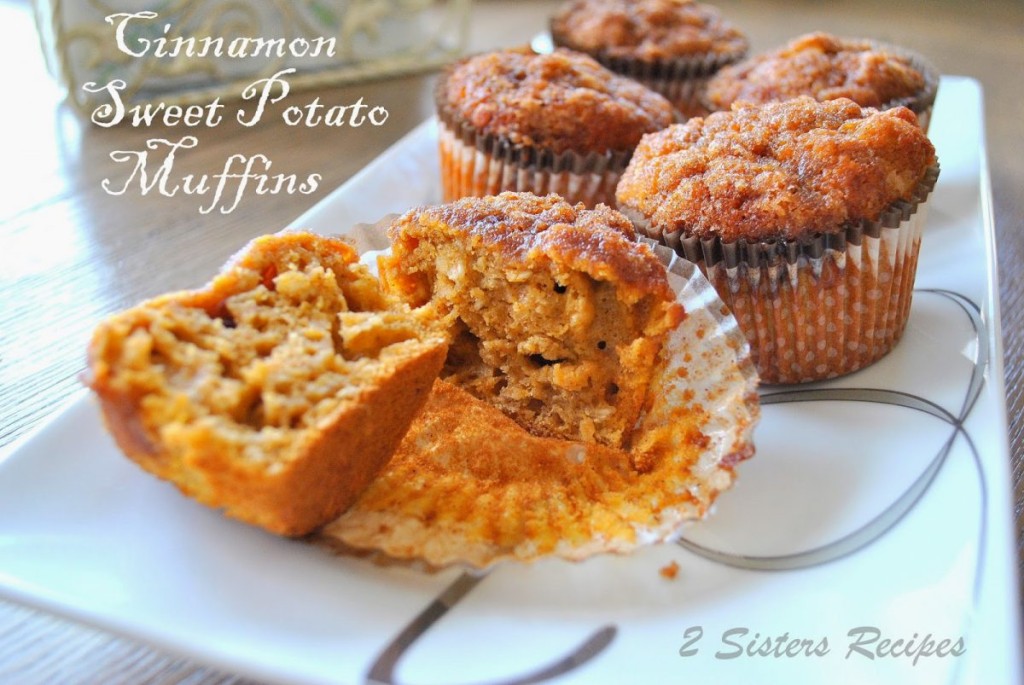 Baked muffins served on a white platter, with one cut in half.