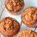 A white and silver platter with baked muffins.