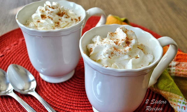 2 mugs on an orange place mat filled with pumpkin spice lattes. by 2sistersrecipes.com