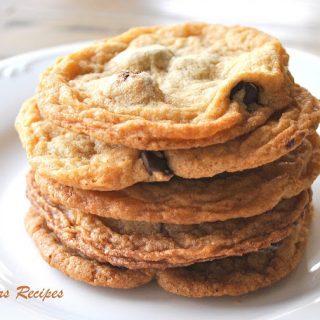 Chocolate Cookies are piled on top of each other on a white plate.