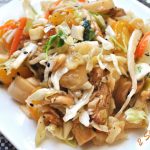 A white plate filled with an Asian Chicken salad.