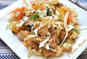 A white plate filled with an Asian Chicken salad.