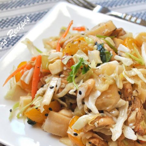A white square plate filled with an Asian-style chicken salad.