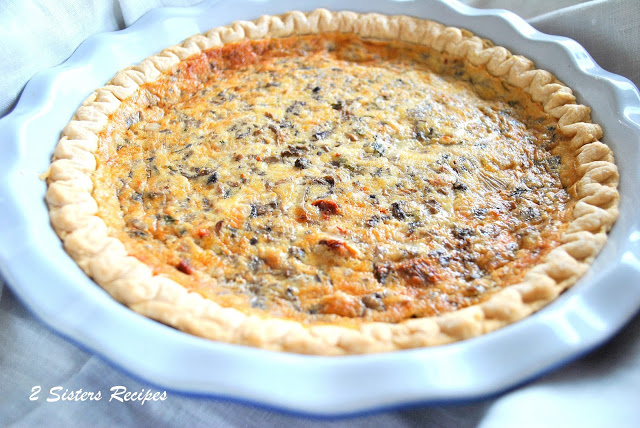A white pie dish with an already baked quiche. by 2sistersrecipes.com