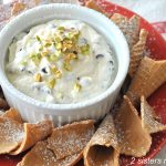 Chocolate Chip Cannoli Dip served in a ramekin with broken sugar comes surrounding the dip.