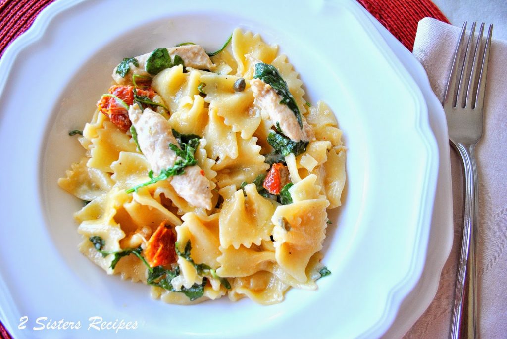 A dish of farfalle pasta with sauteed chicken along with the veggies. by 2sistersrecipes.com 