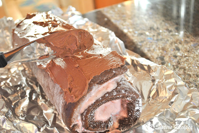 Spreading frosting on the dark chocolate & strawberry ice cream roll. by 2sistersrecipes.com 