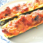 2 zucchini boats baked, filled sausage meat, sauce and melted cheese on top.
