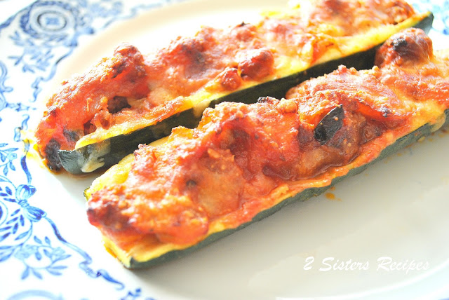 2 zucchini boats baked, filled sausage meat, sauce and melted cheese on top. 