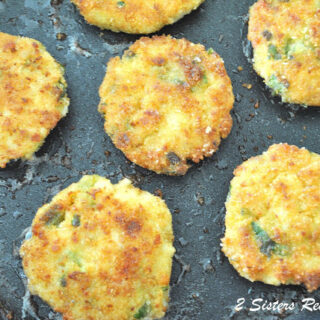 Cod Fish Cakes cooking in a dark skillet.