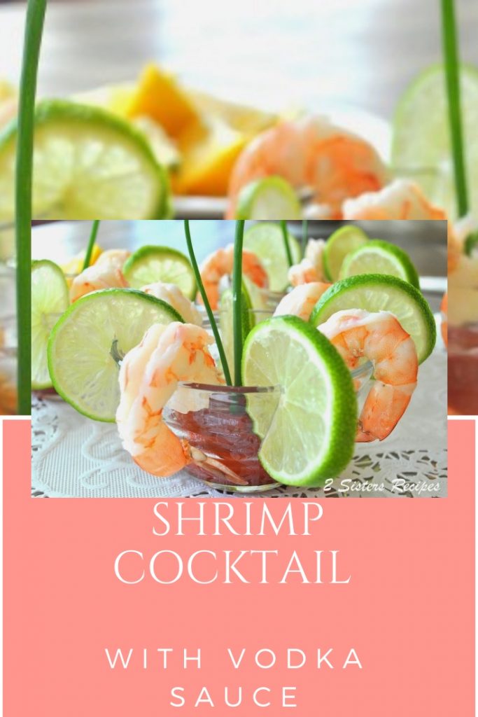 A small glass with chilled shrimp sitting on the rim of the glass bowl with lime slices in between.