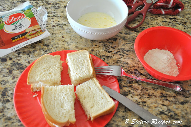 A red plate with a slice of white bread cut into quarters. by 2sistersrecipes.com