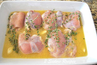 Raw chicken thighs marinating in a baking dish. by 2sistersrecipes.com