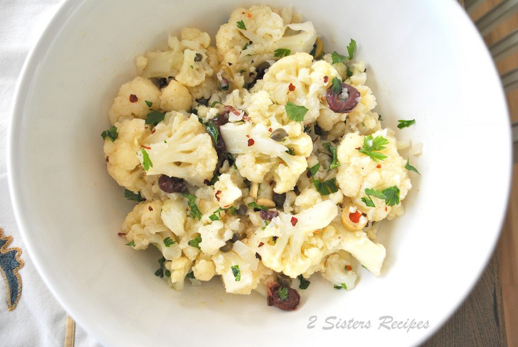 A white bowl filled with a Cauliflower salad. 