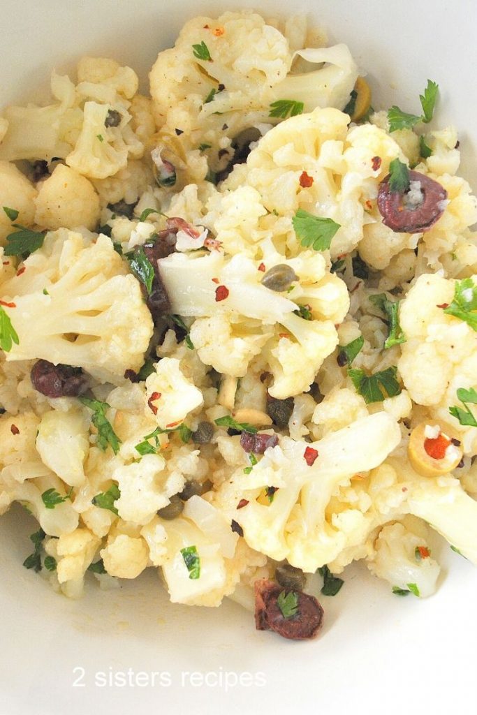 A white bowl filled with a cauliflower salad.