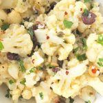 A white bowl filled with a cauliflower salad.