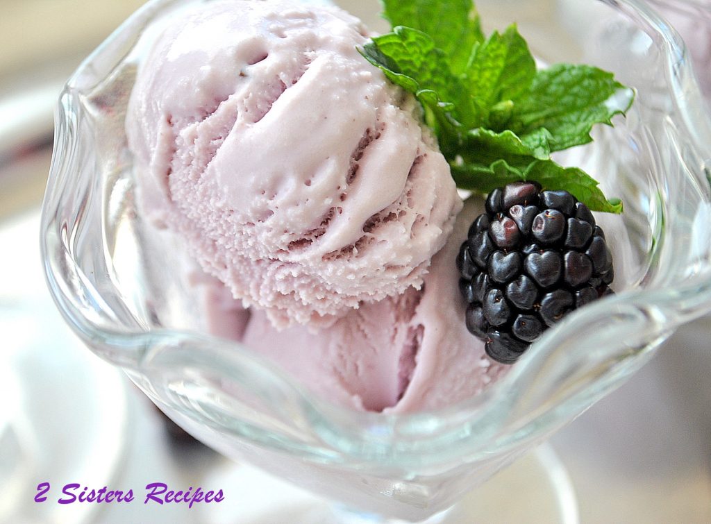 Close up photo of ice cream in a parfait glass with a blackberry and mint. by 2sistersrecipes.com 