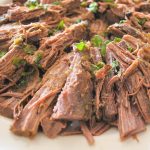 Cut into pieces brisket and laid on a white plate for serving.