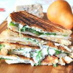 Grilled Cheese and Pear Sandwich are plied on a wooden board.