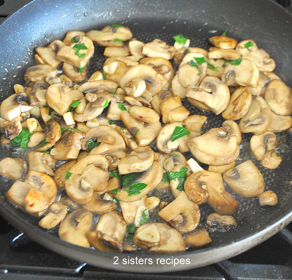 A large skillet cooking mushrooms with parsley. by 2sistersrecipes.com