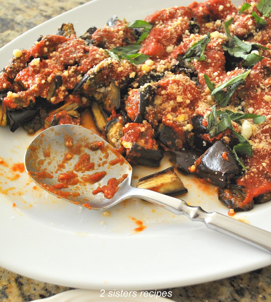 A white platter filled with roasted eggplant topped with tomato sauce and grated cheese. Most Popular Eggplant Recipes , a platter of eggplant Parm. by2 sistersrecipes.com
