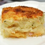 A serving of our mother's mashed potato pie served on a white plate.