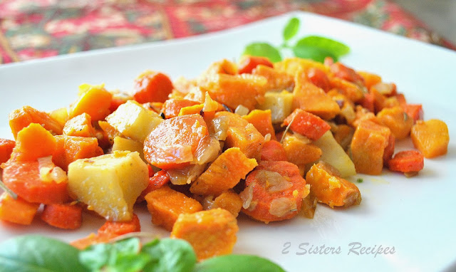 A white serving  platter filled with Roasted Sweet Potatoes with Carrots and Pancetta 