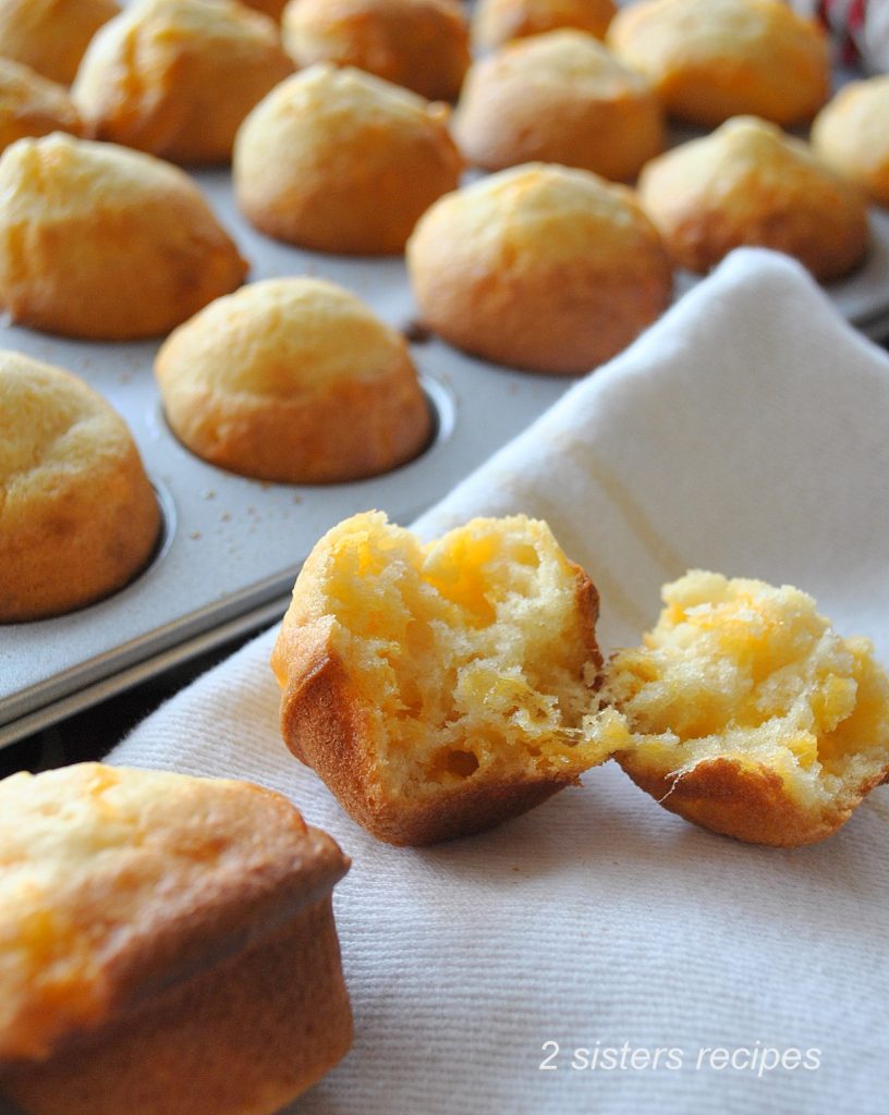 One mini biscuit is opened in half on a white towel. by 2sistersrecipes.com