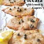 A white platter filled with slices of cooked veal stopped with capers.