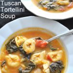 Two bowls of tortellini soup with Swiss chard.