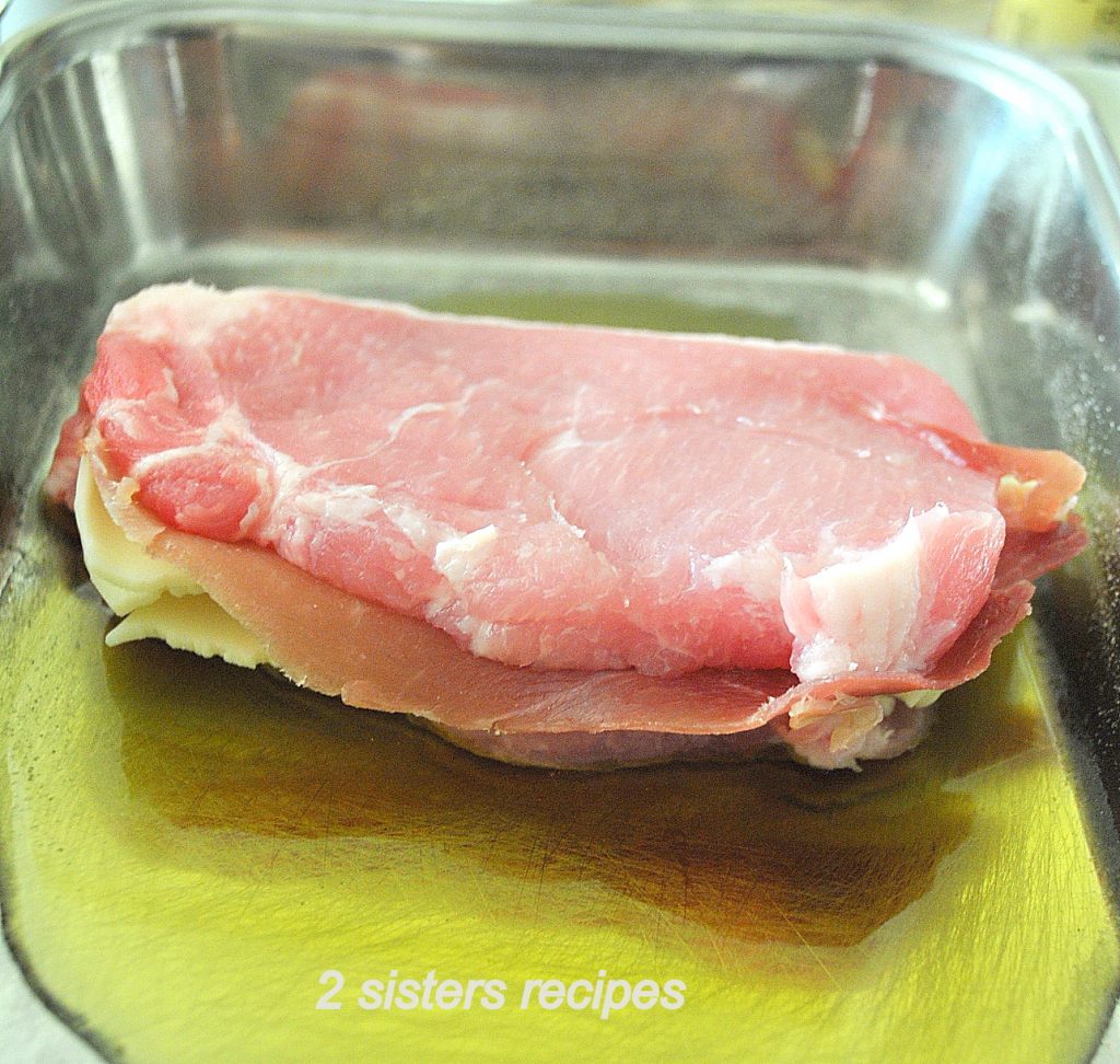 One raw pork chop stuffed with Prosciutto and Cheese and dipped in olive oil.  by 2sistersrecipes.com