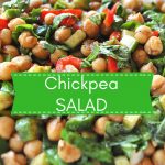 A serving bowl filled with a chickpea salad with chopped cucumbers and peppers.