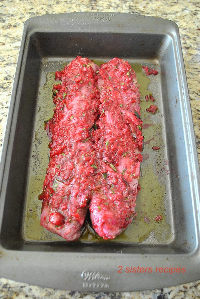 Photo of two pork tenderloins marinating with cranberry salsa. by 2sistersrecipes.com 