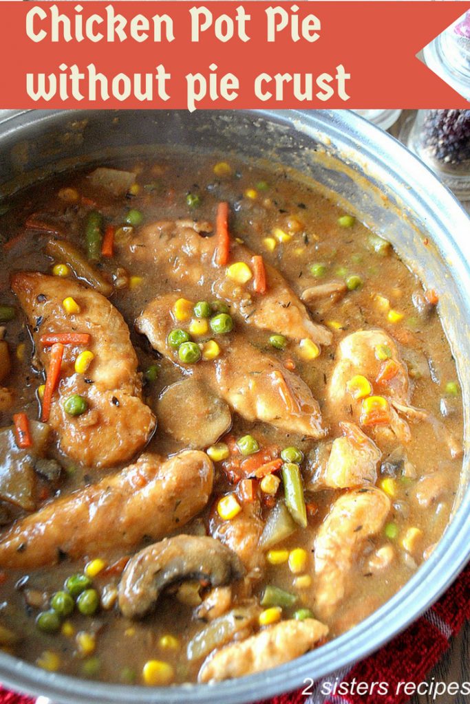 A large skillet loaded with pieces of cooked chicken tenders, veggies and brown gravy. 