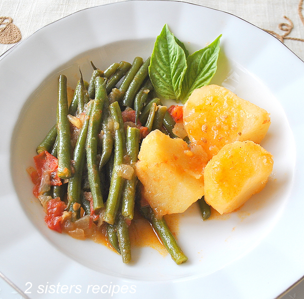 String Beans Tomato Potato Stew served in a white plate.